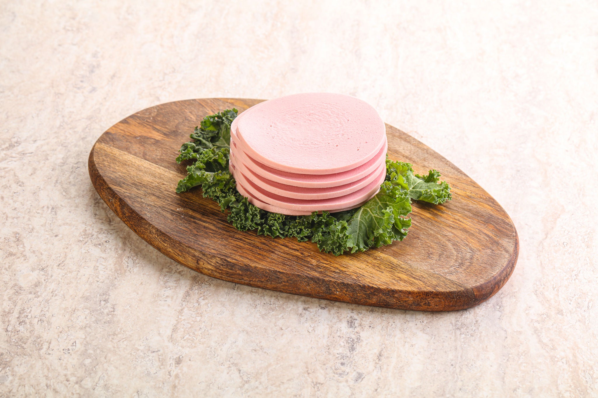 Sliced Bologna on Wooden Board with Kale Garnish