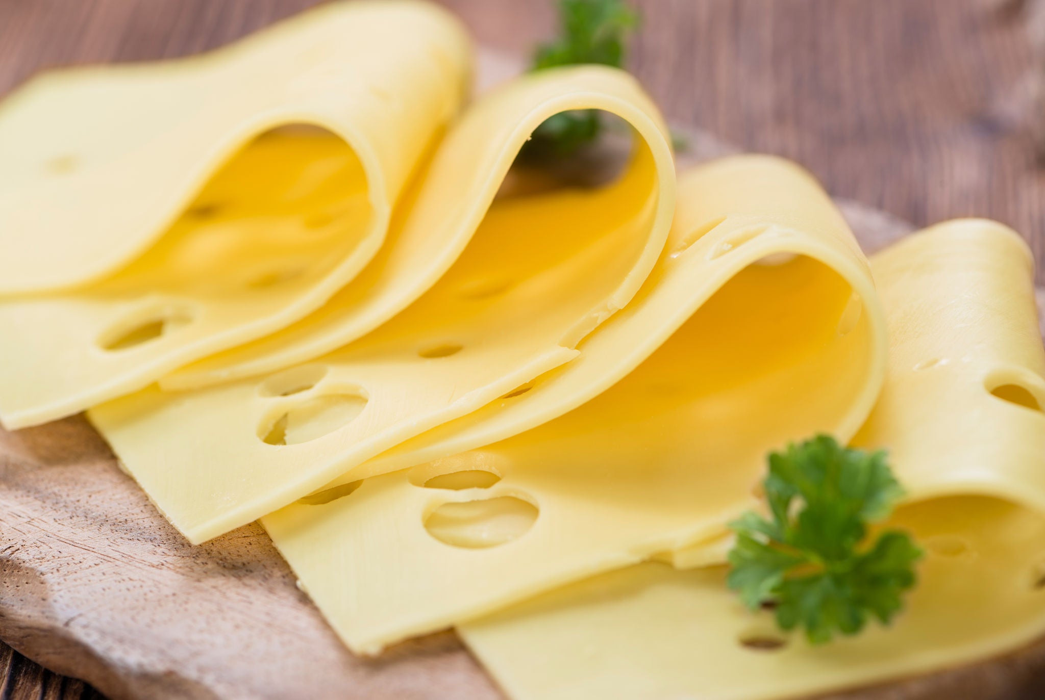 Swiss Cheese Slices on Wooden Board