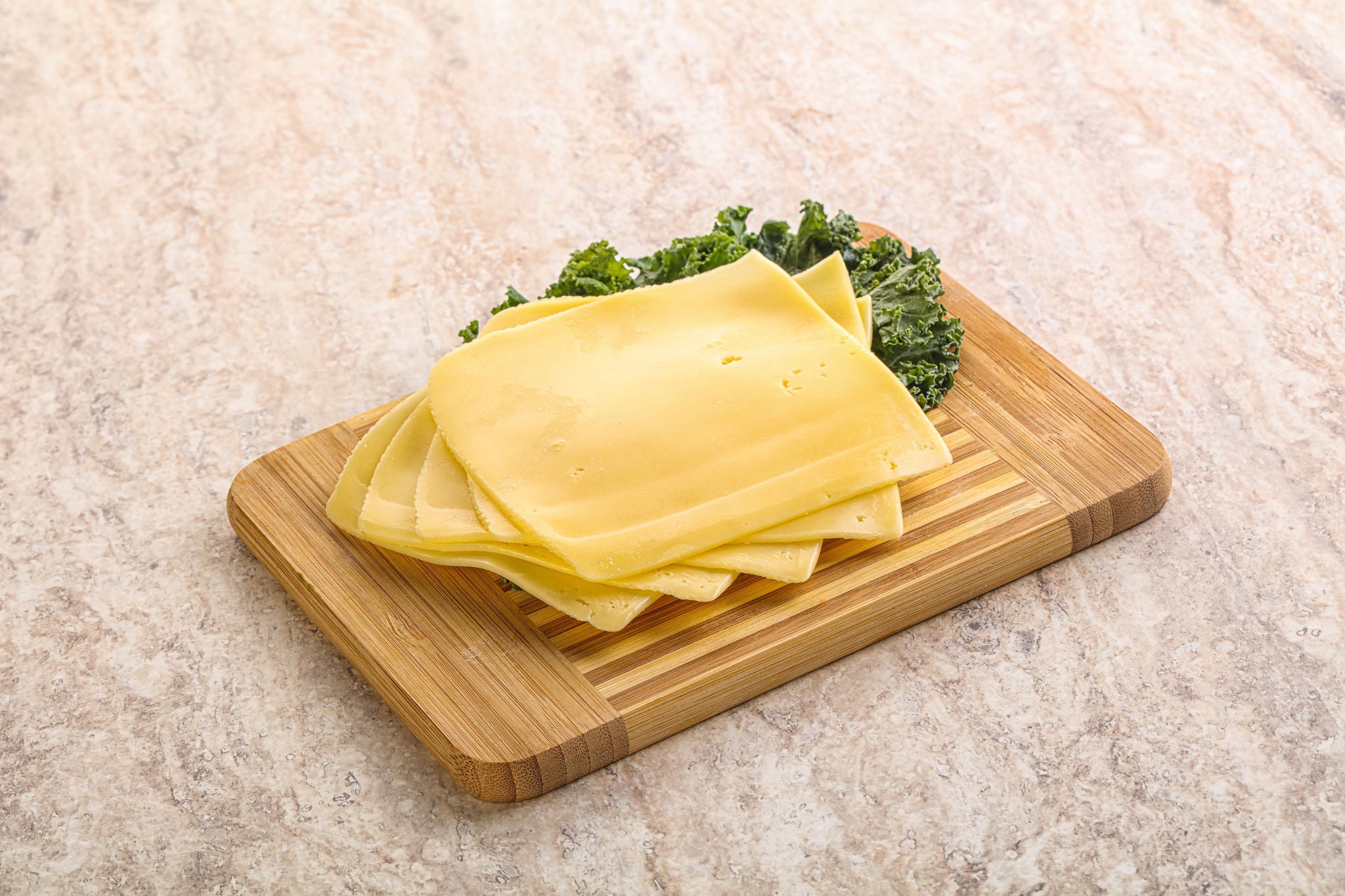 Cheese Slices on Wooden Board with Kale Cheese Slices on Wooden Board with Kale