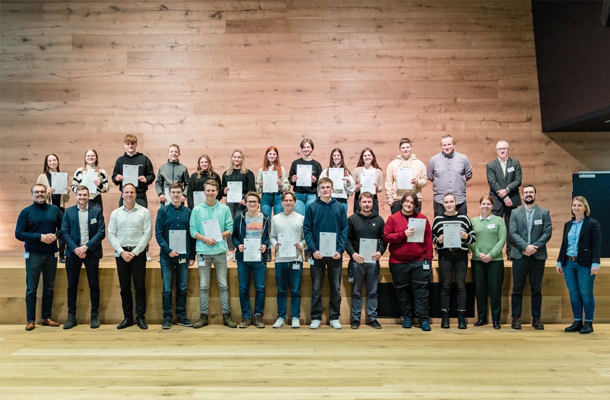 Group Photo with Certificates on Wooden Stage Group Photo with Certificates on Wooden Stage